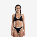 Front view of a model wearing a black halter-neck bikini set with ivory contrast trim and a high-waisted belted bottom.