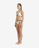 Side profile of the Ursula ivory bikini showcasing the rib nylon fabric and the contrasting black waist belt for a flattering silhouette.