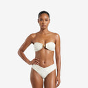 Front view of a model wearing the ivory Soleil Plisse bandeau bikini set featuring a textured plissé finish and a central gold sun hardware detail.