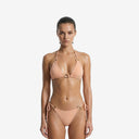 Front view of a model wearing the UNICA Mimosa peach bikini set featuring a triangle top and side-tie bottoms with elegant gold ring hardware.