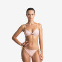 Front view of a woman wearing the SIRI pink bikini set from the Bali swimwear collection, featuring a geometric triangle top and side-tie bottoms.