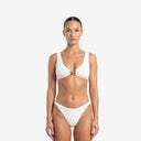 Front view of a model wearing a white Coralie 2P bikini set featuring crinkle textured Hunza fabric and a signature gold charm detail.