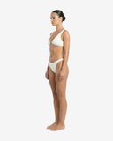 Side profile of the white Hunza crinkle bikini showcasing the supportive stretch fit and minimal curve-enhancing silhouette.