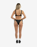 Back view of the black two-piece swimsuit highlighting the thick adjustable shoulder straps and classic coverage bottoms