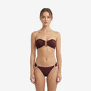 Front view of a model wearing a cherry dark red bandeau bikini set featuring a center metal ring detail and tango-style bottoms.