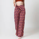 Woman wearing a brown crop top and patterned pants on a white background