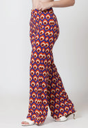 Woman wearing a brown crop top and patterned pants on a white background