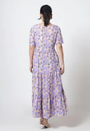 Woman wearing a purple floral dress on a white background