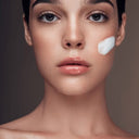 beautiful woman with face product on cheek