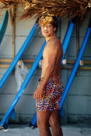 Side profile of the men's leopard swim shorts showing the athletic fit and the vibrant orange and purple animal print pattern.
