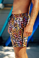 Bali beachwear shop featuring men's leopard-print swim shorts with two secure side zip pockets and two open pockets for functional surf and sand use.